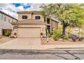 A two-story beige home featuring a well-manicured yard with a two car garage and tile roof at 26815 N 65Th Ave, Phoenix, AZ 85083