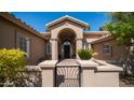 Charming close up of covered entryway with arched columns and decorative black metal gate to a quaint front yard at 3020 E Rockledge Rd, Phoenix, AZ 85048