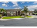 Single-story home with stone accents, well manicured lawn, desert landscaping, and a three-car garage at 3425 E Birchwood Pl, Chandler, AZ 85249