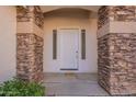 Close-up of the welcoming front door, framed by stone accents and a neutral color palette at 3524 E Derringer Way, Gilbert, AZ 85297