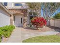 Inviting front entrance featuring a stone-accented facade and vibrant flowering shrubbery at 3524 E Derringer Way, Gilbert, AZ 85297