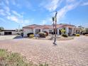 Charming one-story home with a brick driveway, desert landscaping, and an arched entryway at 3943 E Omega Cir, Mesa, AZ 85215