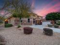 Stunning exterior of a two-story home with a well-manicured front yard at sunset at 4122 E Burnside Trl, Cave Creek, AZ 85331