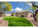 Lush backyard featuring manicured lawn, landscaping, and a covered patio perfect for relaxation and entertainment at 44 W Teakwood Pl, Chandler, AZ 85248