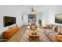 Cozy living room featuring neutral furniture and a sliding door to the outside at 45997 W Windmill Dr, Maricopa, AZ 85139