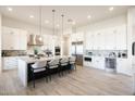 Modern kitchen with white cabinetry, stainless steel appliances, and a large center island with seating at 510 E Woburn Ln, Phoenix, AZ 85085