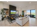 Bright living room with modern fireplace, TV, neutral-toned sofa, and sliding glass doors to outdoor space at 510 E Woburn Ln, Phoenix, AZ 85085