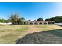 Spacious lawn featuring an single-story home with a red tile roof and an arched walkway at 5501 E Camelback Rd, Phoenix, AZ 85018