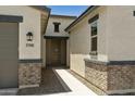 Inviting home entrance featuring a walkway, stylish brick accents, and neutral stucco at 5508 N 192Nd Ave, Litchfield Park, AZ 85340