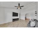 Bright living room with tile floors, ceiling fan, and a wall-mounted TV for a modern, minimalist aesthetic at 635 W Pecos Ave, Mesa, AZ 85210