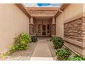 Inviting walkway leading to the front door, framed by lush green bushes and stone pillars at 7339 W Monte Lindo Ln, Glendale, AZ 85310