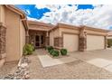 Welcoming home exterior with stone accents, three-car garage, and desert landscaping at 7339 W Monte Lindo Ln, Glendale, AZ 85310