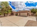 Beautiful home featuring a desert landscape, large driveway, and three-car garage at 7339 W Monte Lindo Ln, Glendale, AZ 85310