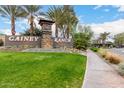 Beautifully landscaped entrance to Gainey Ranch with stone signage, mature palm trees, and lush green lawns at 7525 E Gainey Ranch Rd # 110, Scottsdale, AZ 85258