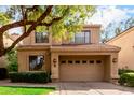 Inviting two-story home featuring a tile roof, well-manicured landscaping, and a spacious two-car garage at 7525 E Gainey Ranch Rd # 110, Scottsdale, AZ 85258