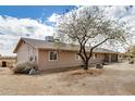 Side view of a ranch-style home with neutral paint and minimal desert landscaping at 8431 W Planada Ln, Peoria, AZ 85383