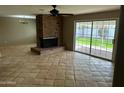 Bright living room with a brick fireplace and sliding glass doors to the backyard at 8601 E Berridge Ln, Scottsdale, AZ 85250