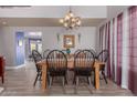 Spacious dining room with modern chandelier, wood table, and light wood flooring at 9116 W Acoma Dr, Peoria, AZ 85381