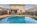 Backyard featuring a swimming pool with safety fence, artificial turf, and covered patio at 11234 W Roma Ave, Phoenix, AZ 85037