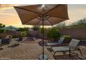Inviting backyard with a brick patio, lounge chairs, and an umbrella for outdoor relaxation at 16424 N 1St Dr, Phoenix, AZ 85023