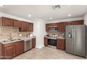 Well-equipped kitchen featuring stainless steel appliances, tile backsplash, and dark wood cabinets at 16833 N 17Th Pl, Phoenix, AZ 85022