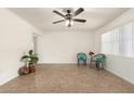 Bright living room featuring neutral tile flooring, ceiling fan, and ample natural light at 16833 N 17Th Pl, Phoenix, AZ 85022