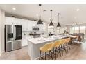 Modern eat-in kitchen featuring a central island, stainless steel appliances, and wood floors at 17845 W Red Fox Rd, Surprise, AZ 85387
