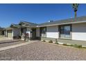 Low angle view of a one story house with manicured gravel yard and desert landscaping at 1946 E Wesleyan Dr, Tempe, AZ 85282