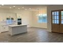 Open-concept kitchen featuring a quartz island, stainless steel appliances, and wood look tile flooring at 231Xx W Gloria Ln, Wittmann, AZ 85361