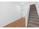 Bright hallway features wood-look flooring and a carpeted staircase to the upper level at 2835 W Eagle Talon Rd, Phoenix, AZ 85085