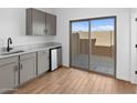 Modern kitchenette includes gray cabinets, light countertops, and sliding glass door to patio at 2835 W Eagle Talon Rd, Phoenix, AZ 85085