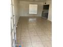 Spacious living room with tiled floors, large window and view to an open-plan kitchen at 3347 E Palm Ln, Phoenix, AZ 85008