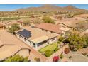 Overhead view showcasing the solar panels, putting green, covered patio, and mountain views in this active adult community at 41105 N Prestancia Way, Anthem, AZ 85086