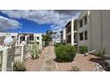 Well-maintained community walkway with landscaping and views of the condo buildings at 5518 E Lindstrom Ln # 1034, Mesa, AZ 85215