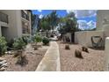 Community walkway with desert landscaping, rocks, and plants leading to parking area at 5518 E Lindstrom Ln # 1034, Mesa, AZ 85215