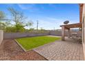 Spacious backyard features a well-maintained lawn, stone patio, and covered patio, offering outdoor comfort at 5819 S 10Th St, Phoenix, AZ 85040