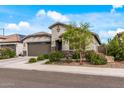 Lovely single-story home with stone accents and lush front yard landscaping at 5831 N 196Th Ln, Litchfield Park, AZ 85340