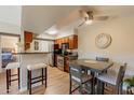 Eat-in kitchen with wood cabinets, black appliances, and adjacent dining area at 5877 N Granite Reef Rd # 1145, Scottsdale, AZ 85250