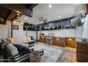 Well-equipped outdoor kitchen with a built-in grill, countertop space, ceiling fan, and comfortable seating area at 8001 N 3Rd Pl, Phoenix, AZ 85020