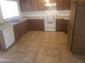 Functional kitchen with white appliances, wood cabinets and ample counter space at 8141 W Elm St, Phoenix, AZ 85033