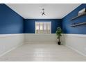Stylish room featuring blue accent wall, white wainscoting, and bright natural light through the shuttered window at 9743 E Torino Ave, Mesa, AZ 85212