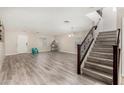 Inviting living room with modern flooring and a staircase featuring a dark wood railing at 11202 W Mckinley St, Avondale, AZ 85323