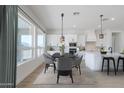 Bright kitchen with a dining area, large windows, modern appliances, and stylish lighting fixtures at 13929 E Barwick Dr, Scottsdale, AZ 85262