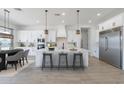 Bright modern kitchen with white cabinets, stainless steel appliances, and a large center island with barstool seating at 13929 E Barwick Dr, Scottsdale, AZ 85262