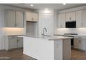This modern kitchen features white cabinets, black stainless appliances, and sleek countertops with backsplash at 17307 W Via Dona Rd, Surprise, AZ 85387