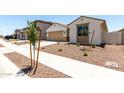Charming single-story home featuring desert landscaping, a two-car garage, and a covered entryway at 17547 W Lupine Ave, Goodyear, AZ 85338