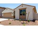 Charming single-story home featuring desert landscaping, a two-car garage, and a covered entryway at 17547 W Lupine Ave, Goodyear, AZ 85338