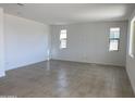 Spacious living room featuring tile floors and multiple windows at 18035 W Vogel Ave, Goodyear, AZ 85338