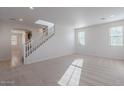 Spacious living room with neutral carpet, staircase, recessed lighting, and light walls for a modern look at 1940 N 78Th Gln, Phoenix, AZ 85035