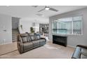 Cozy living room with plush seating, and neutral decor, leading to the kitchen and featuring a modern ceiling fan at 2601 S Entwistle St, Gilbert, AZ 85295